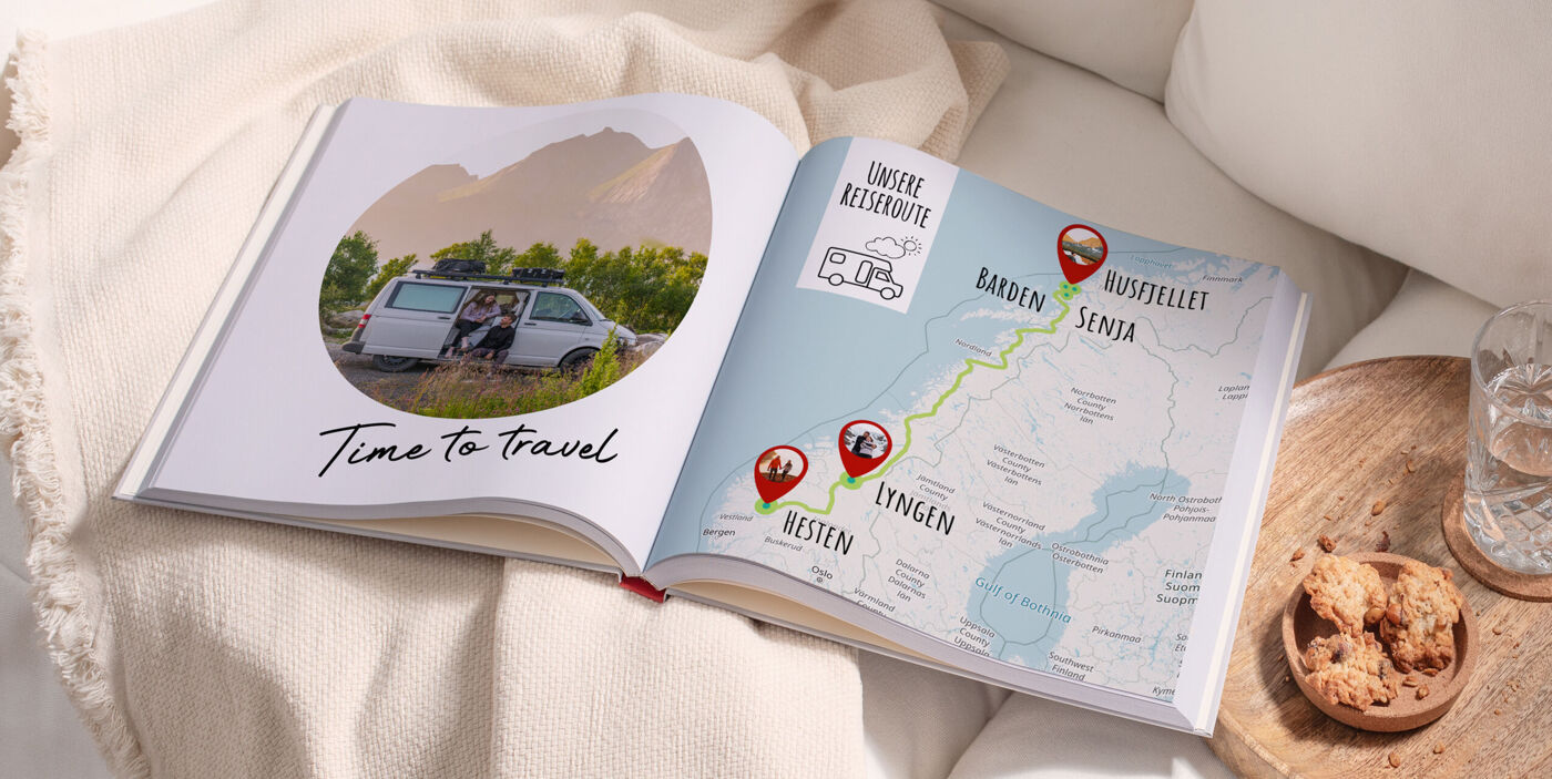 Offenes CEWE FOTOBUCH zeigt eine Reisekarte und glückliche Menschen beim Reisen.
